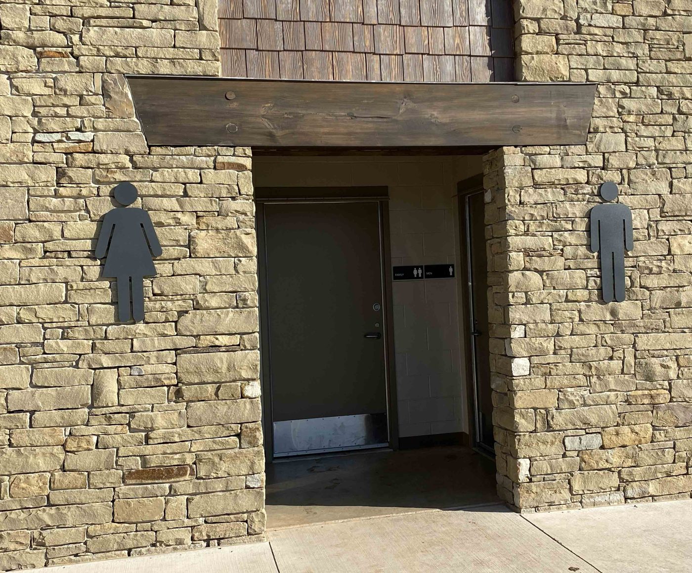 Cut figures over stone restroom entries