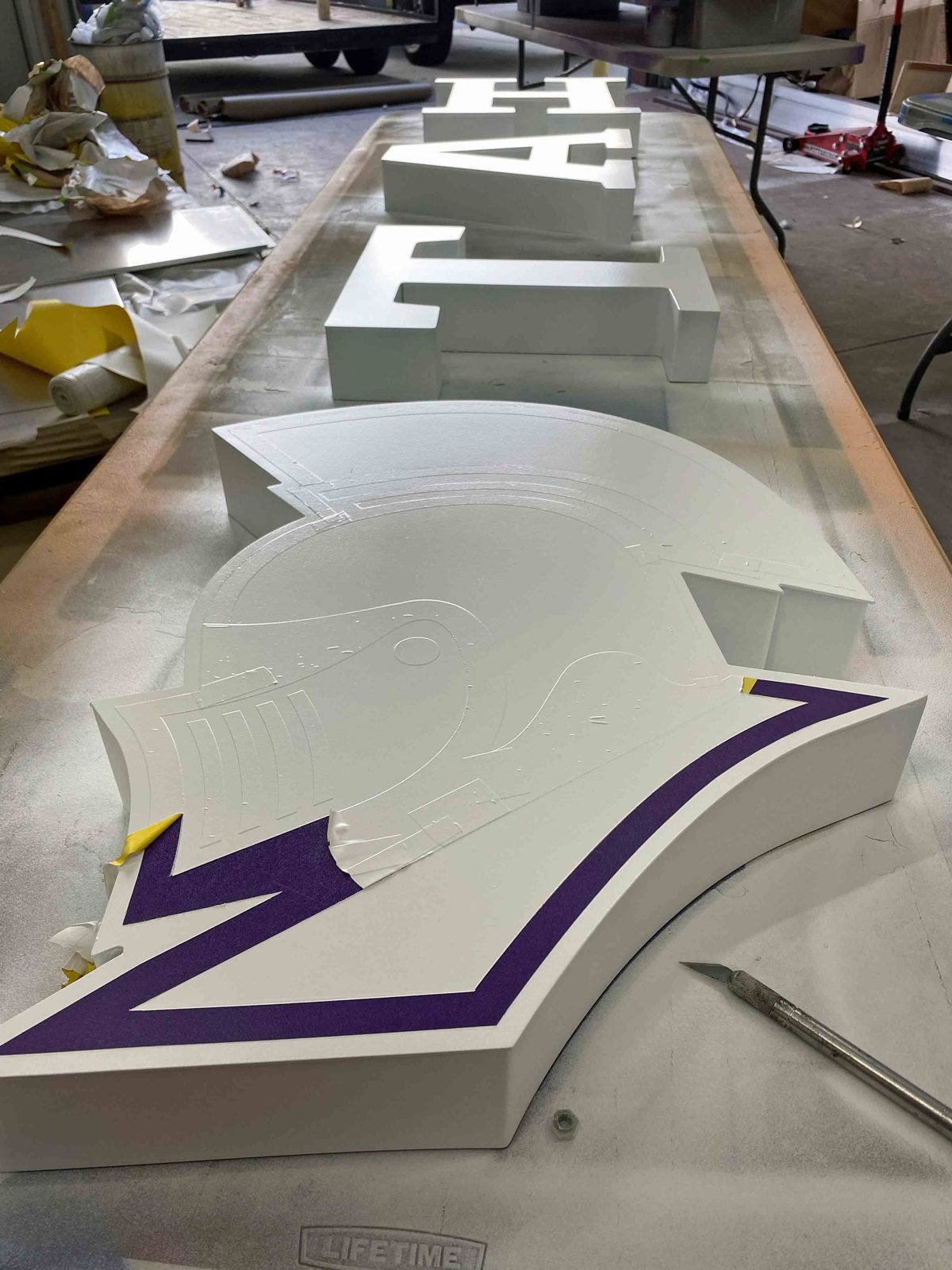 Cut letters and mascot in the shop